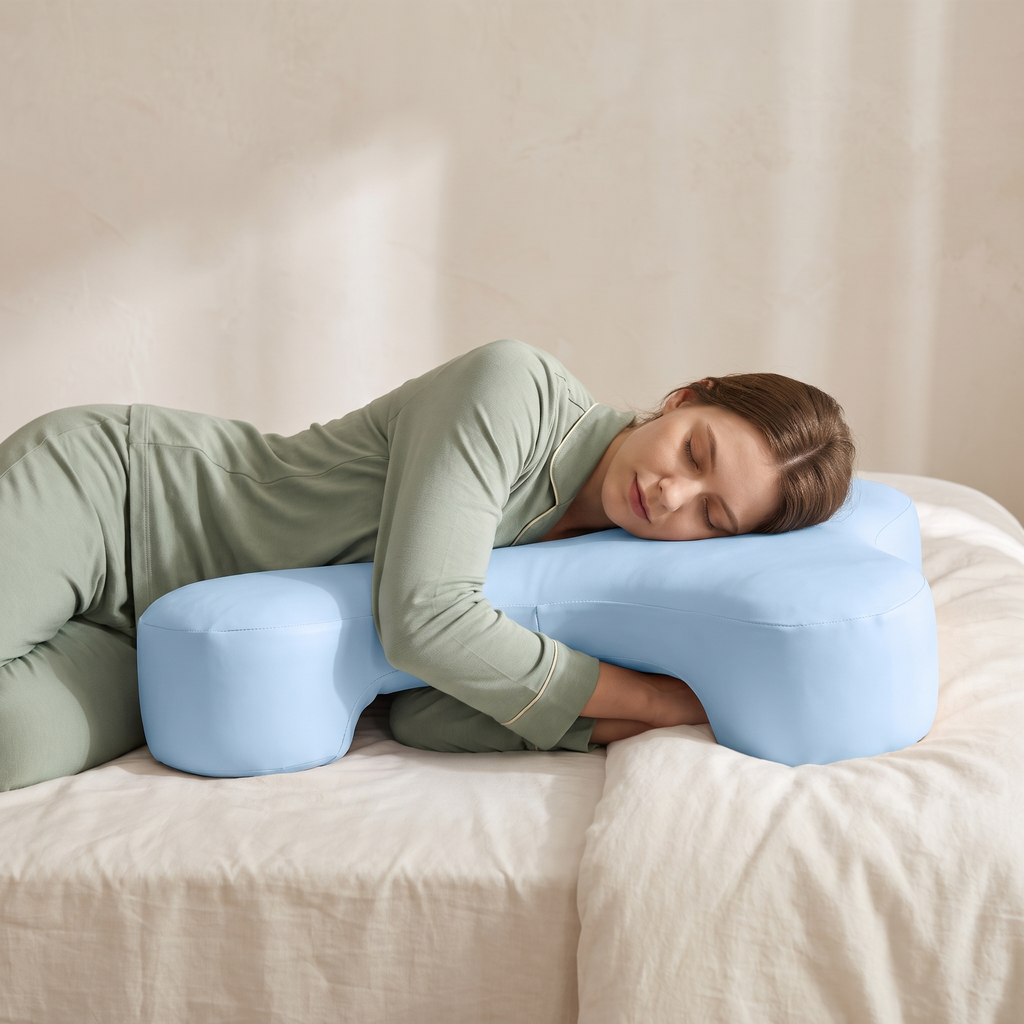 Woman sleeping on her side with her arm through the tunnel of the Cradle arm pillow