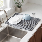 Rill gray silicone dish drying mat by the sink, draining water from washed dishes